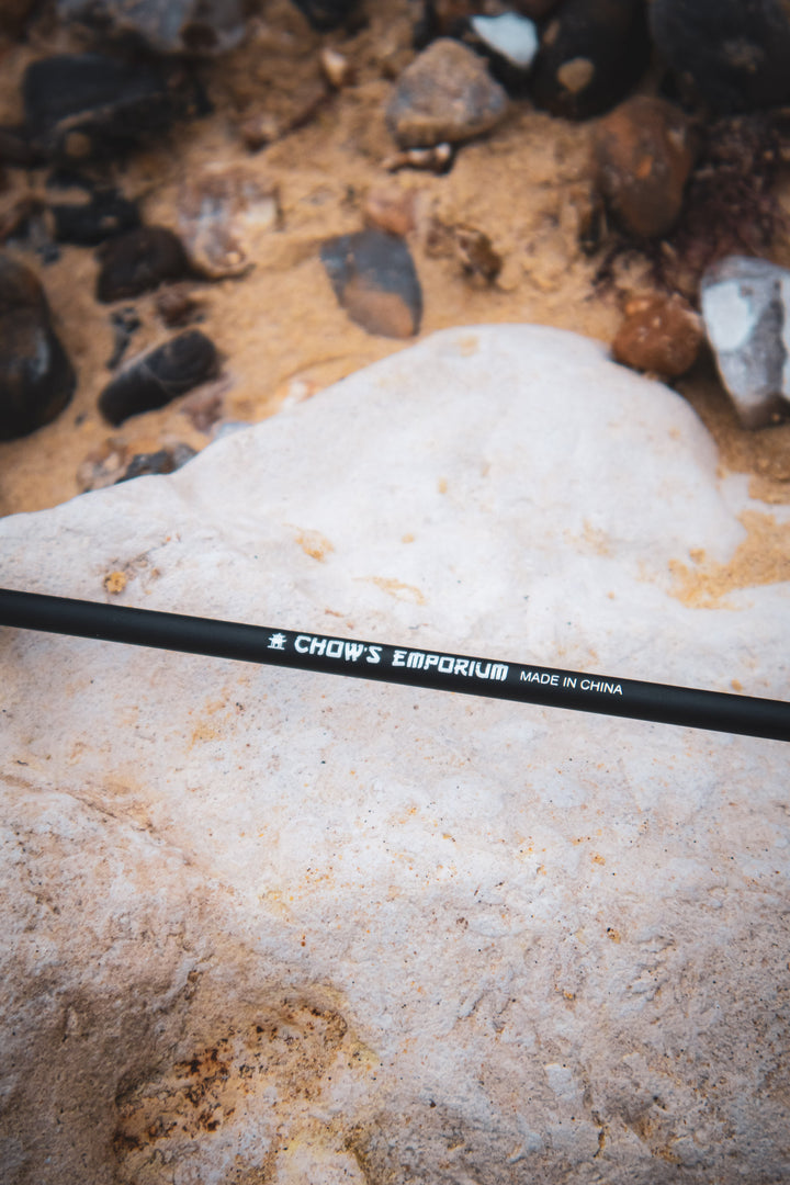 Black arrow with visible brand name on a sandy and rocky surface