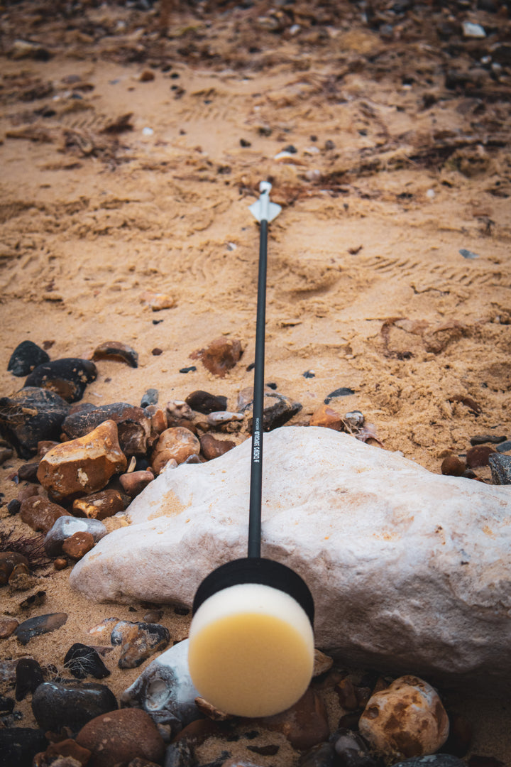 black arrow with foam head head on the beach
