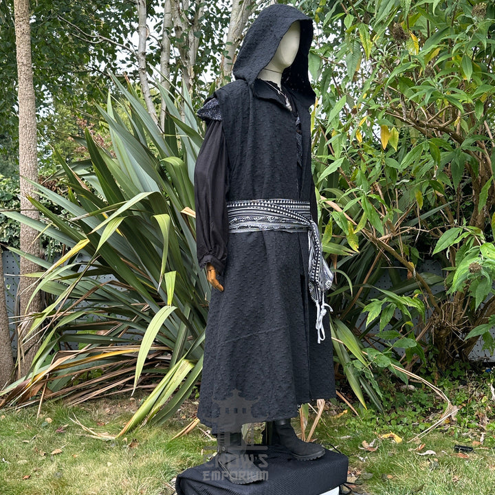 Medieval LARP costume side view featuring black sleeveless robe, hood, shirt, trousers, and sash. For Renaissance Faire and historical roleplay events.
