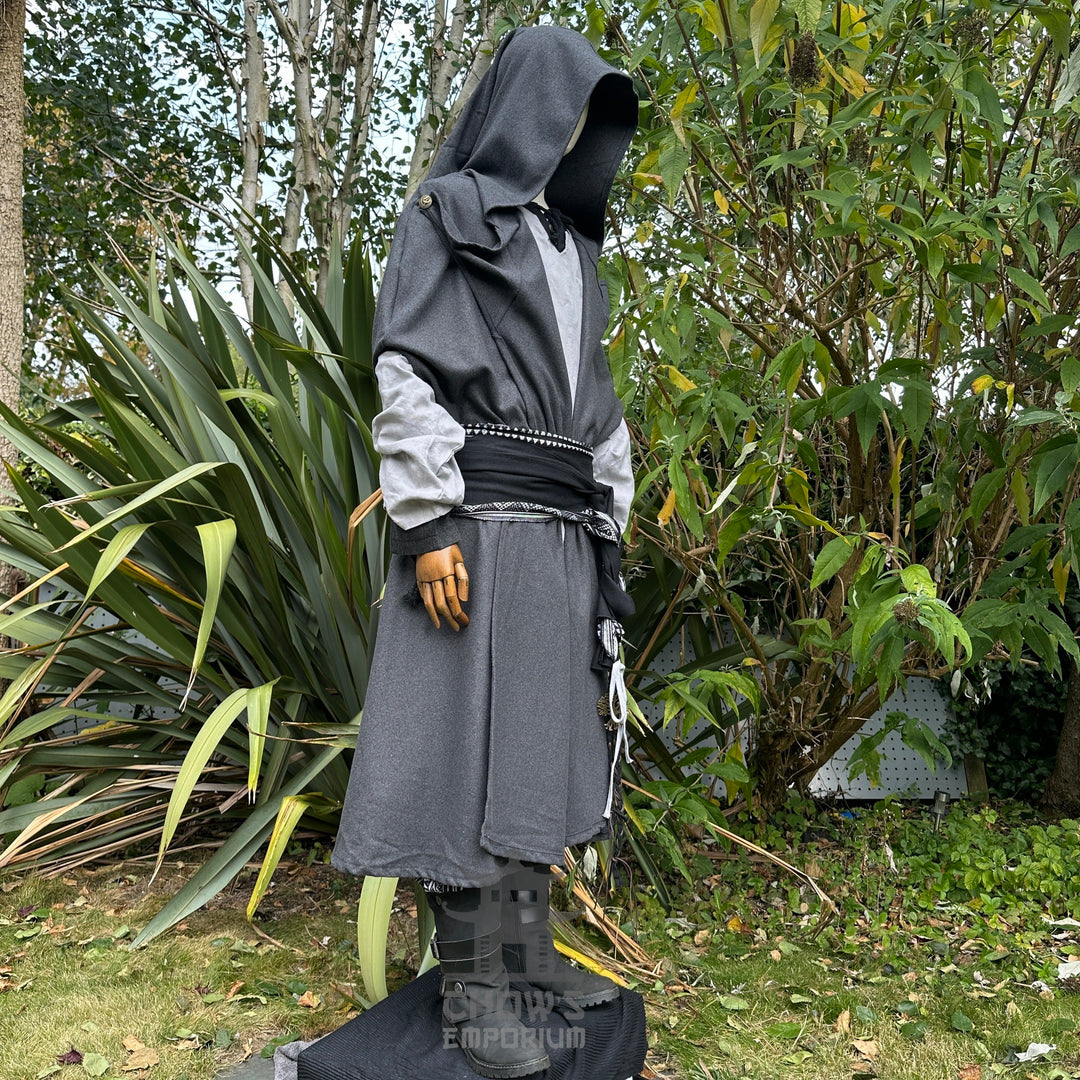 Medieval LARP costume side view featuring grey hooded cloak, tunic, and a black and white sash - ideal for cosplay, LARP, and Renaissance Faire wear.