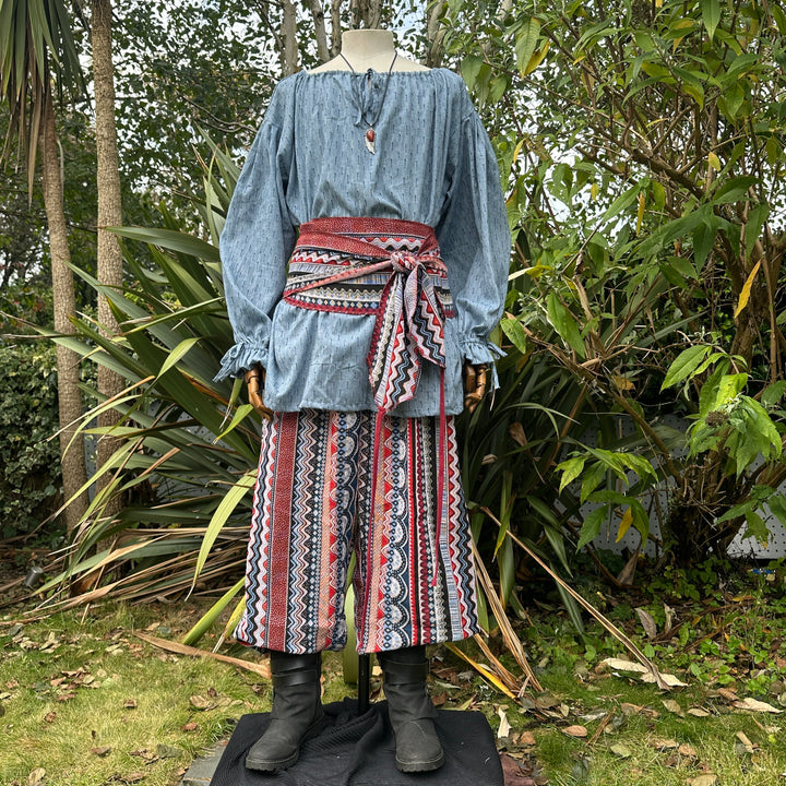 3 piece outfit with blue shirt, and multi striped trousers and sash
