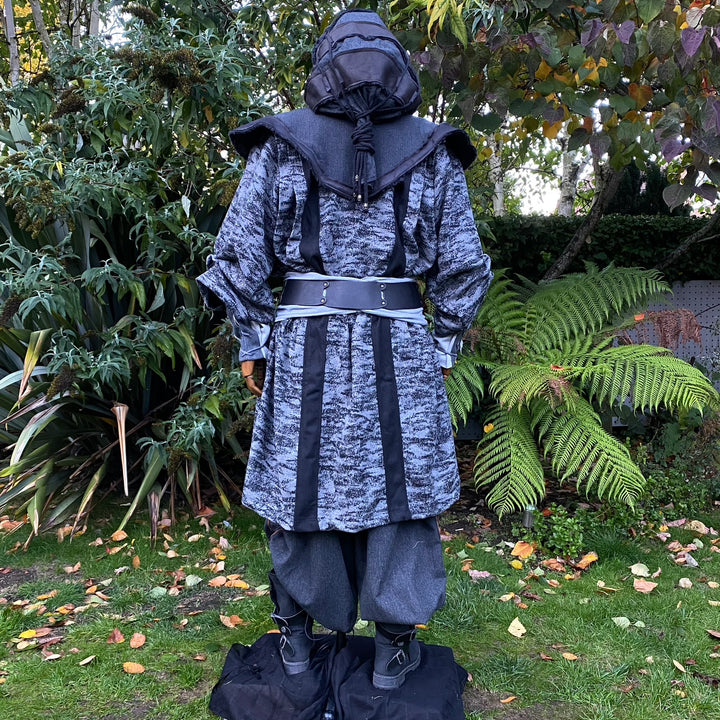 Medieval LARP costume back view, featuring faux leather hood and waistcoat, grey and black hooded robe, and a sash. For Renaissance Faire and historical roleplay events.