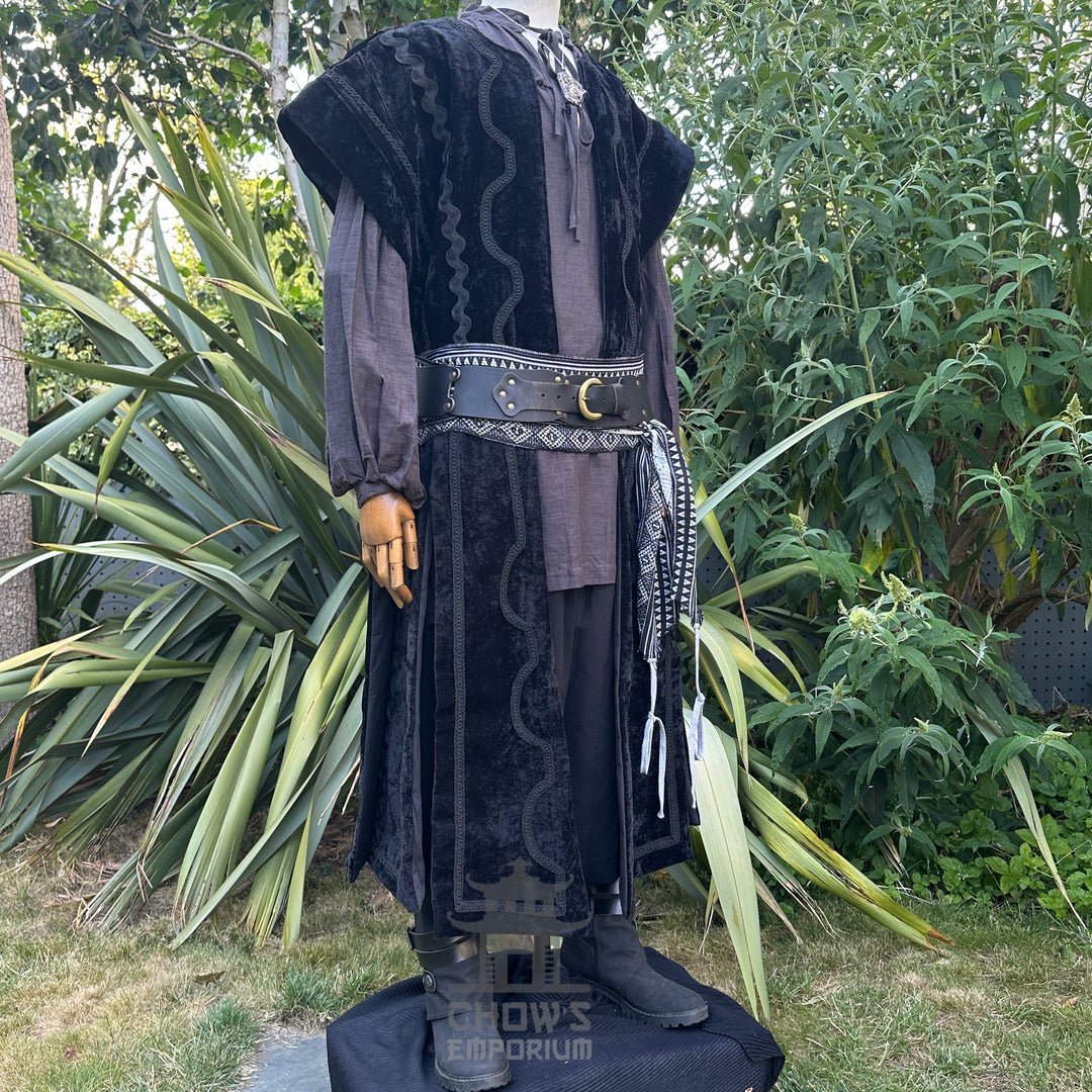 Medieval LARP costume side view featuring waistcoat, hood, vambraces, shirt, trousers, and sash. For Renaissance Faire and historical roleplay events.