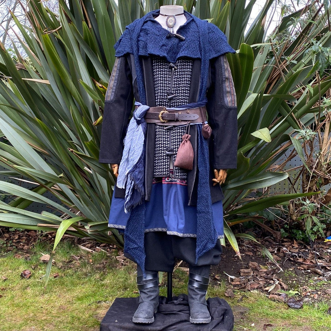 Medieval LARP costume front view, featuring a black and grey wool jacket with ornate panels, a wool hood, tunic, pants, sash and necklace. For Renaissance Faire and historical roleplay events.