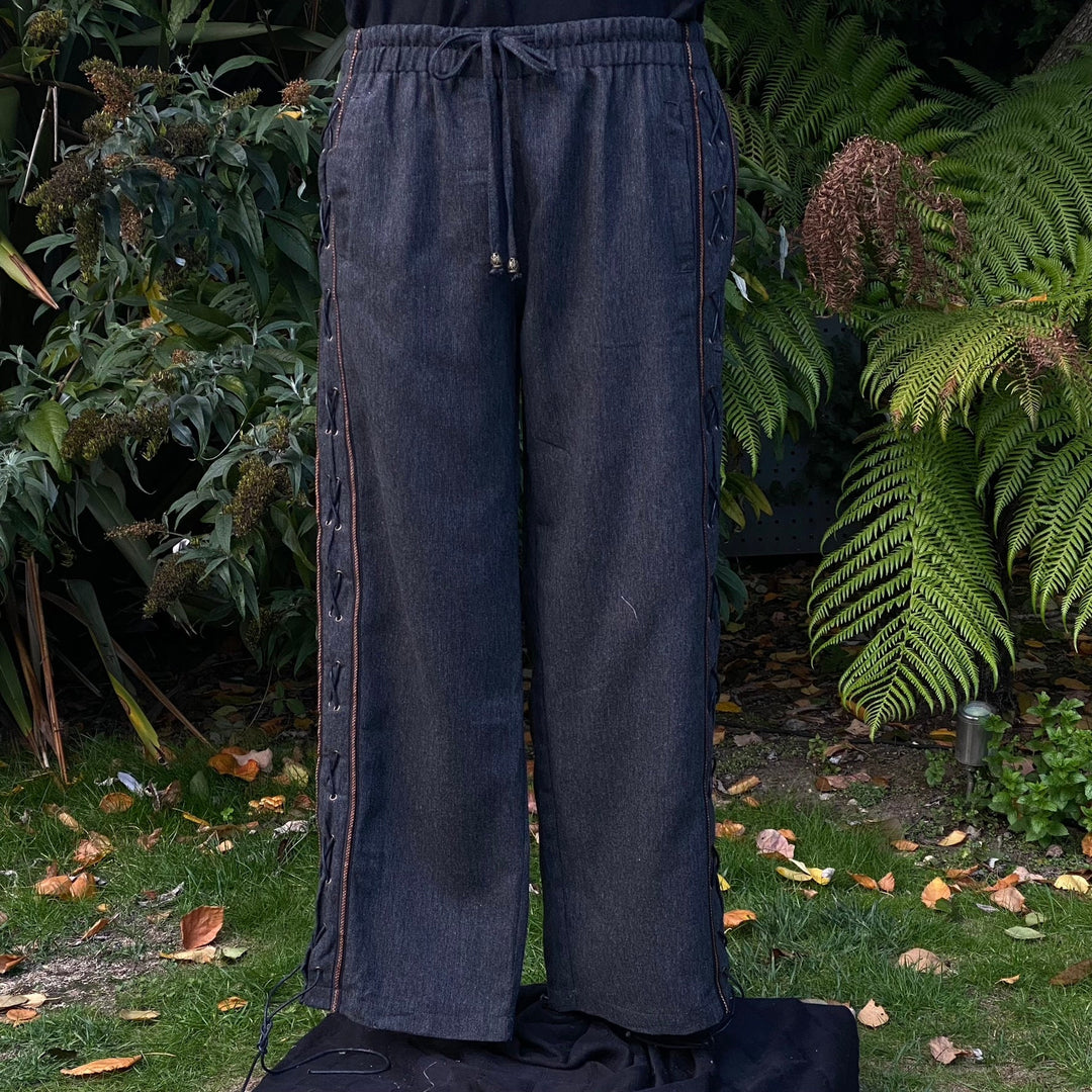 Front view of grey wool medieval trousers with faux leather side lacing and braided trim