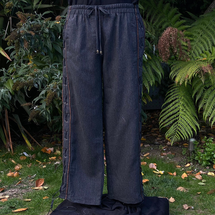Front view of grey wool medieval trousers with faux leather side lacing and braided trim