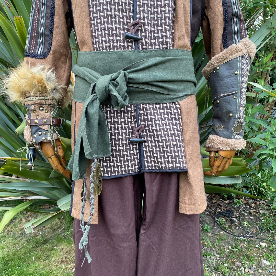 A Green Wool LARP Sash. The Viking Sash is a Woollen sash that works well by itself, or underneath a LARP Belt. The LARP Sash is 300cm long, and can comfortably wrap around you. The Medieval Sash has a decorated metal accessories that adds to your LARP Character, Cosplay, or Ren Faire event.