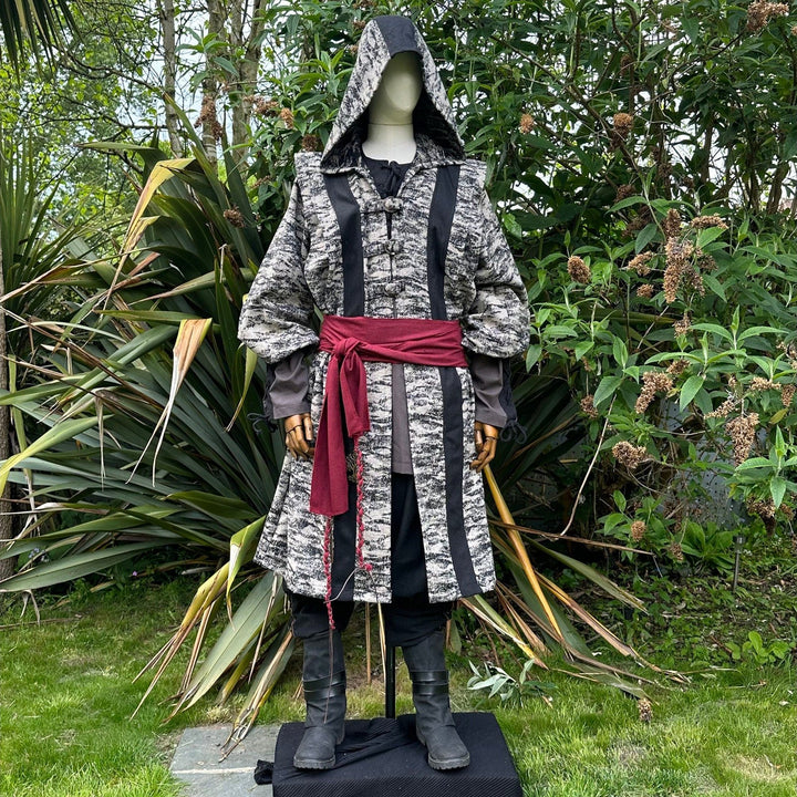 Medieval LARP costume front view, featuring brown and black hooded robe, two-tone shirt, trousers and sash. For Renaissance Faire and historical roleplay events.