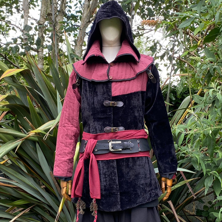 Front view of a medieval LARP costume, featuring a black and red gambeson jacket, matching snood hood, black leather belt, and red woolen sash. Medieval costume for Renaissance Faires and roleplay events.