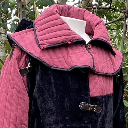 This Padded LARP Hood comes in Black and Red Faux Suede. This Viking Hood has a Snood style, and is Water Resistant. The Gambeson Mantle of the Medieval Hood keeps you warm and dry. Perfect for your LARP Character and LARP Costume, Cosplay Event, and Ren Faire.