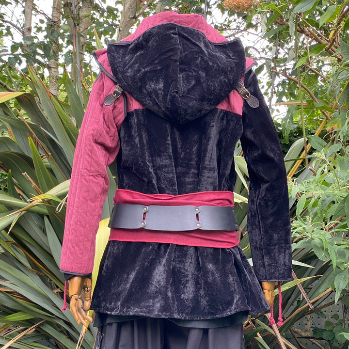 Back view of a medieval LARP costume, featuring a black and red gambeson jacket, matching snood hood, and two-tone shirt. Medieval costume for Renaissance Faire and roleplay events.