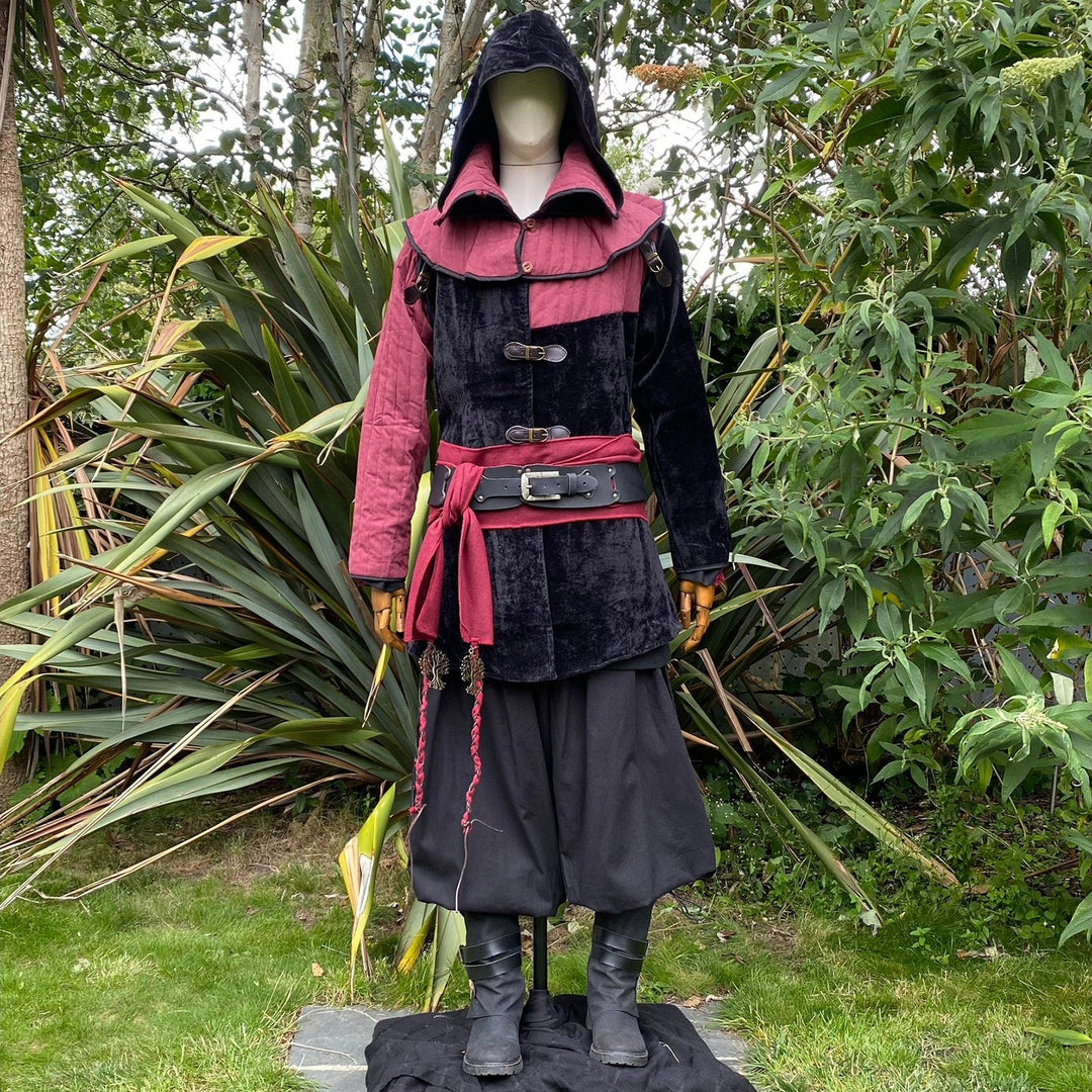 Front view of a medieval LARP costume, featuring a black and red gambeson jacket with removable sleeves, matching hood, shirt, pants, leather belt, and woolen sash. For Renaissance Faire and roleplay events.