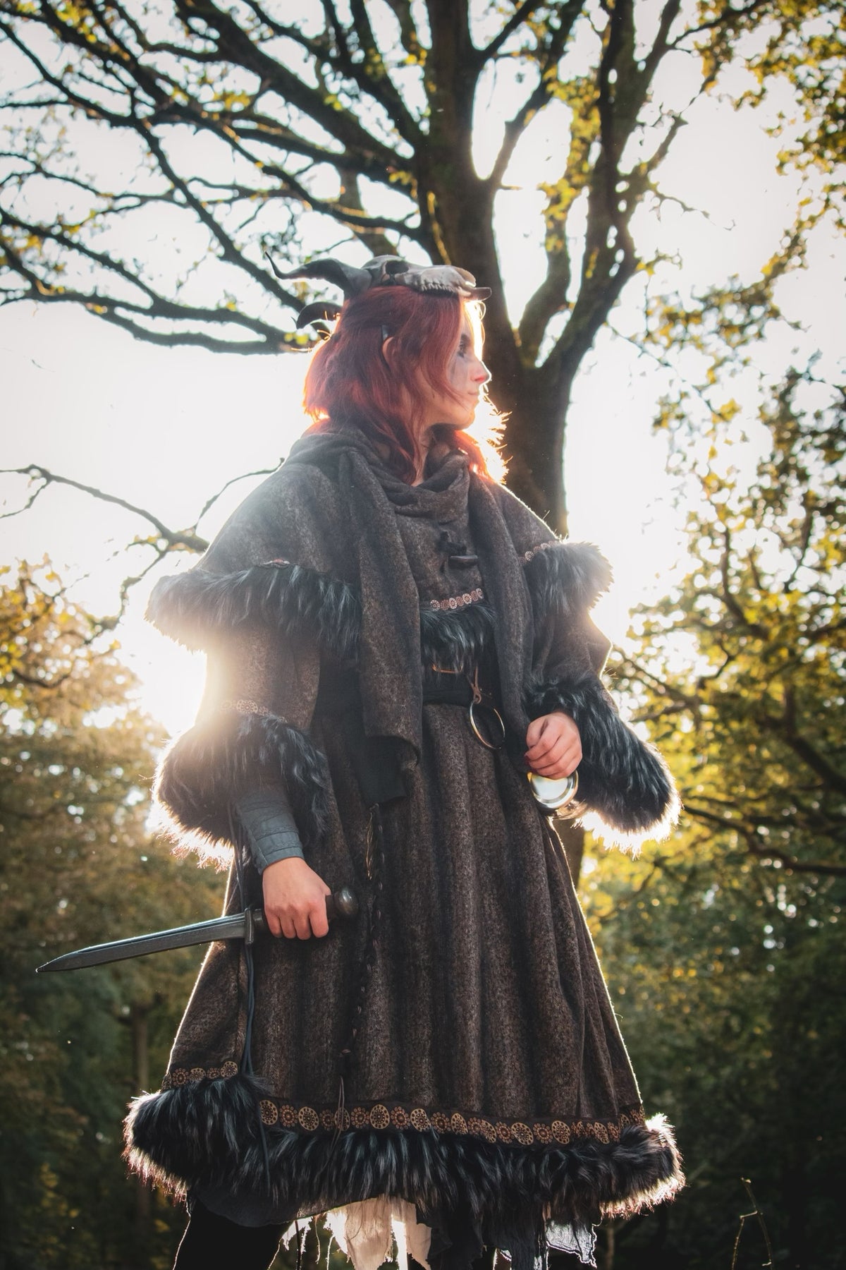 Medieval LARP mohair hood with faux fur trim, backlit forest scene.