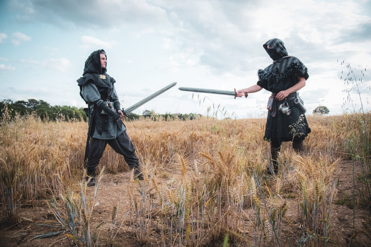 Barbarian LARP costume: faux leather tunic, mohair hood, side view in field.