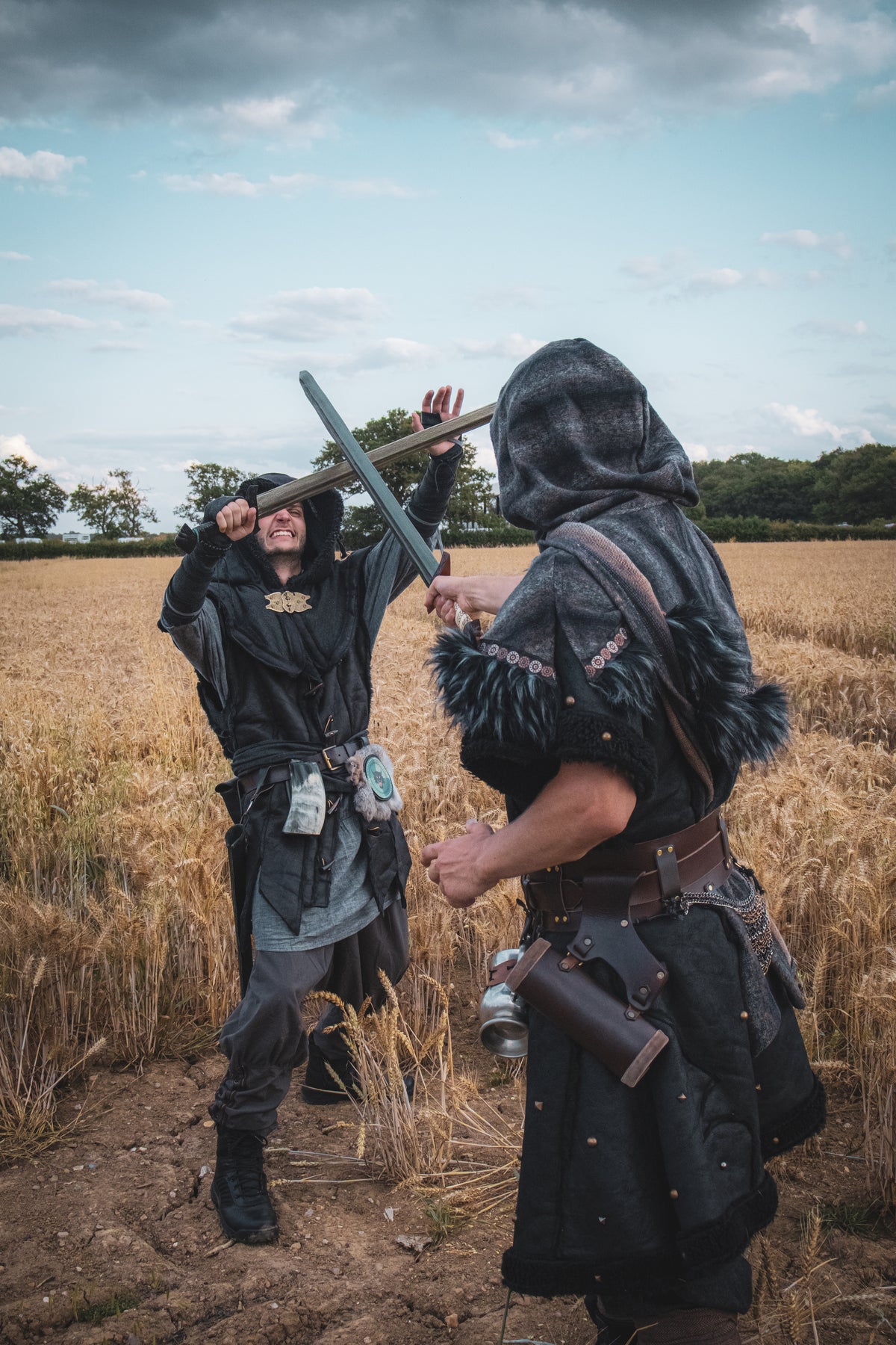 Barbarian fighter in faux leather tunic and mohair hood for medieval LARP combat.