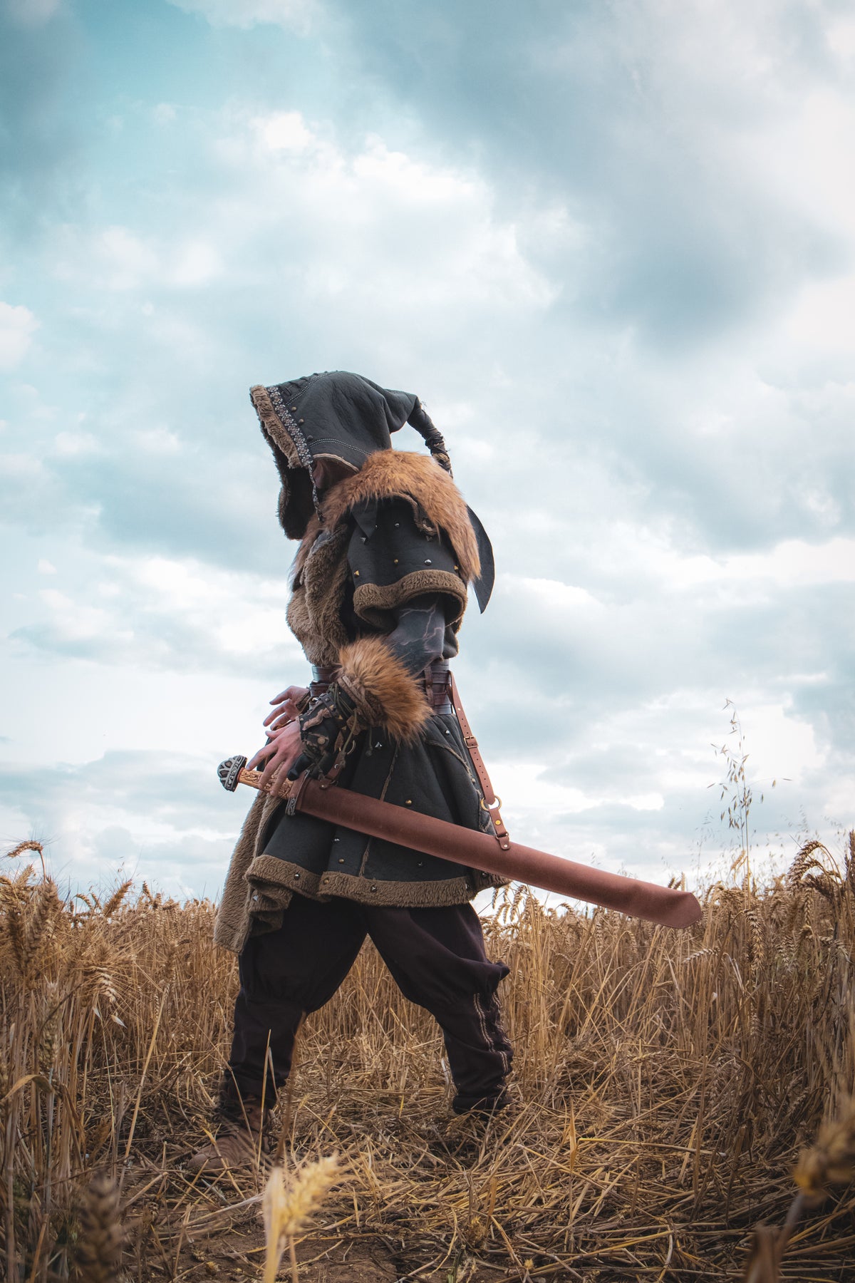 Barbarian LARP set with tunic, hood, and vambraces in a wheat field.