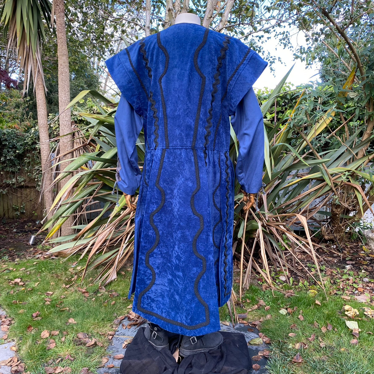 Back view blue LARP waistcoat with ornate trim, long sleeves.