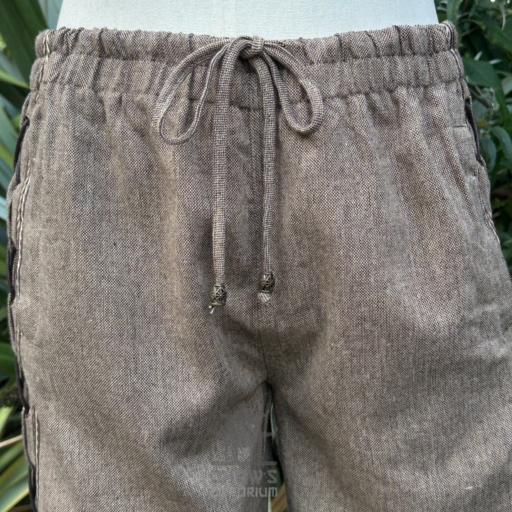 close-up of brown wool medieval trousers lace and braid trim 