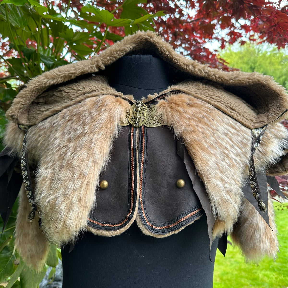 Fur-trimmed hooded tunic with ornate clasp for LARP, front view in nature.