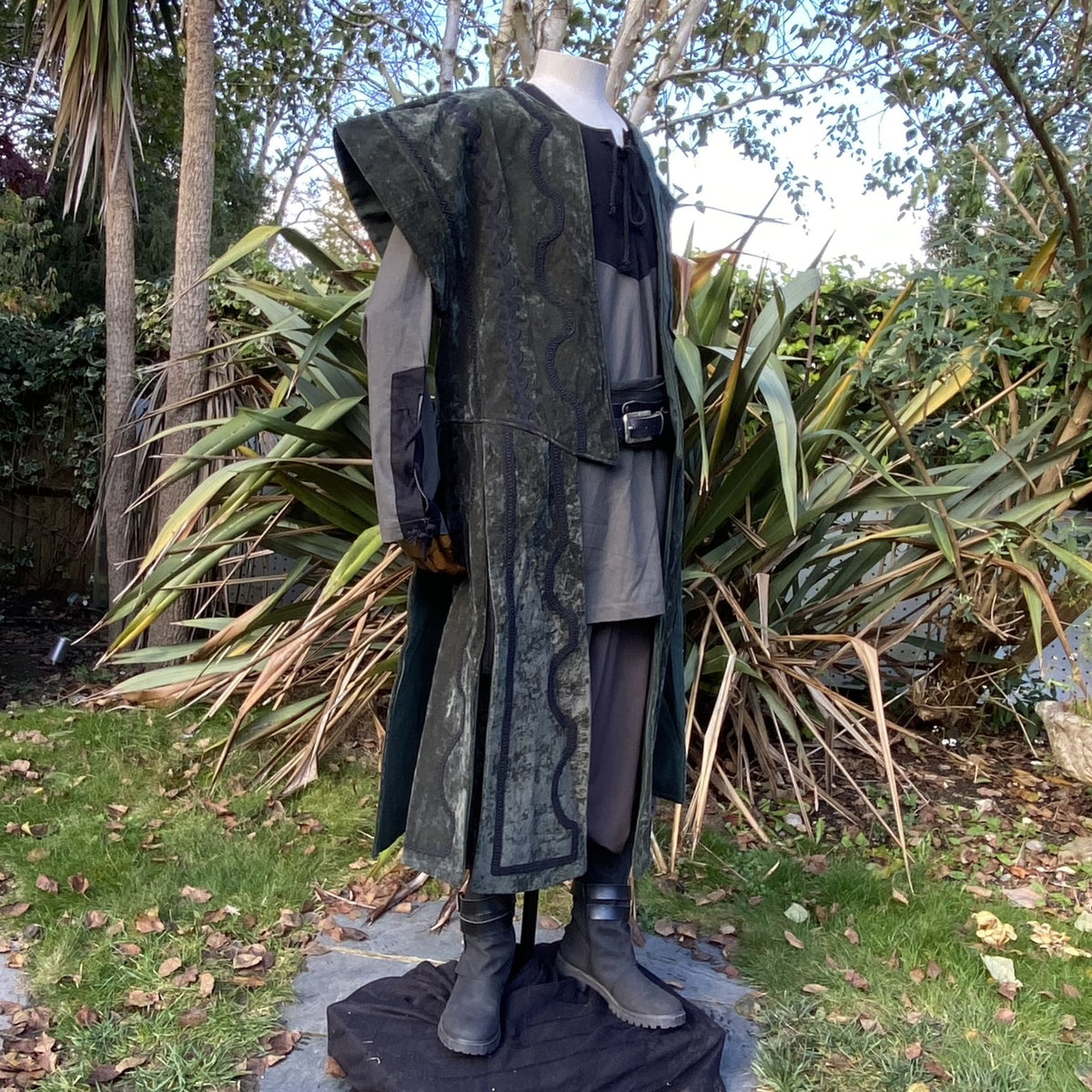 Side view of green medieval waistcoat showing suede-effect fabric and structured shoulder design.