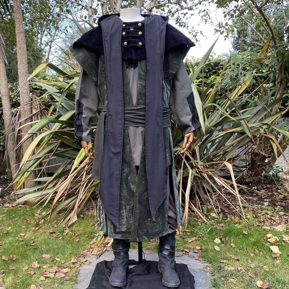 Outdoor photo of green suede-effect wizard waistcoat styled with belt for LARP or medieval events.