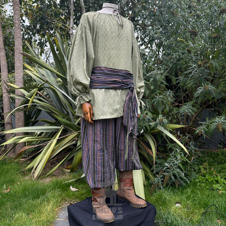 Medieval LARP outfit side view, featuring a green shirt, striped trousers and sash. For Renaissance Faire and historical roleplay events.