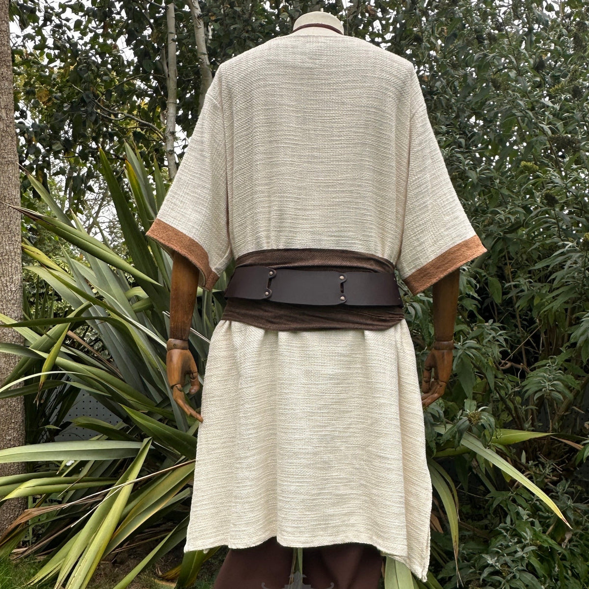 White and brown woven medieval tunic with dark belt, back view, LARP attire.