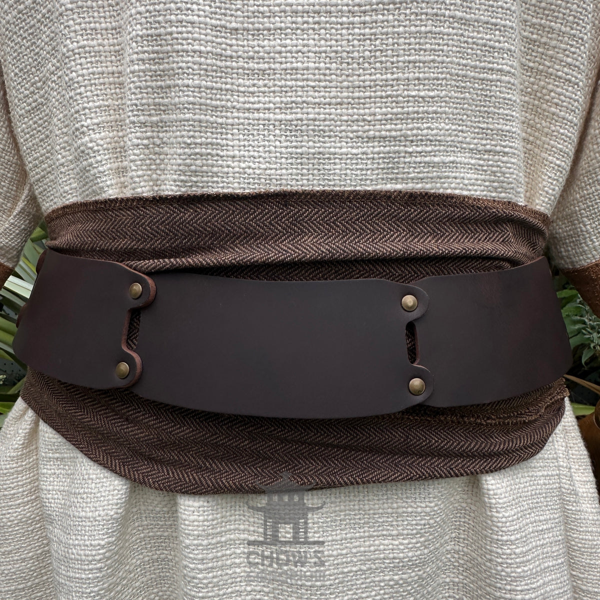 White and brown woven medieval tunic with wide belt, detailed close-up.