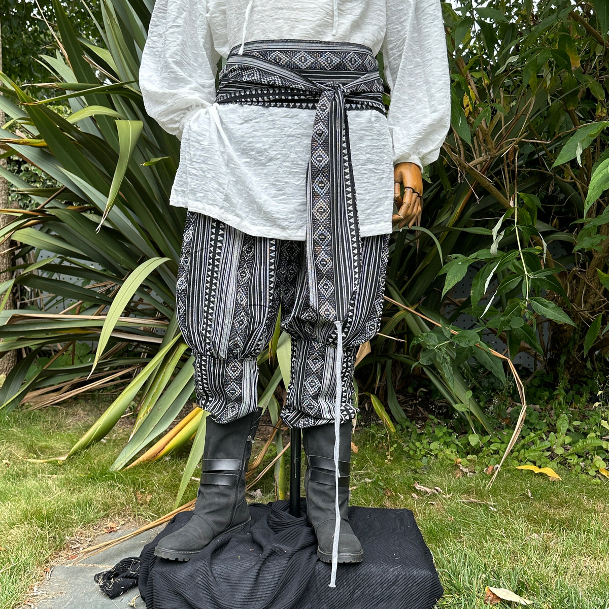 White medieval shirt, black patterned pants, and sash for LARP, front view.