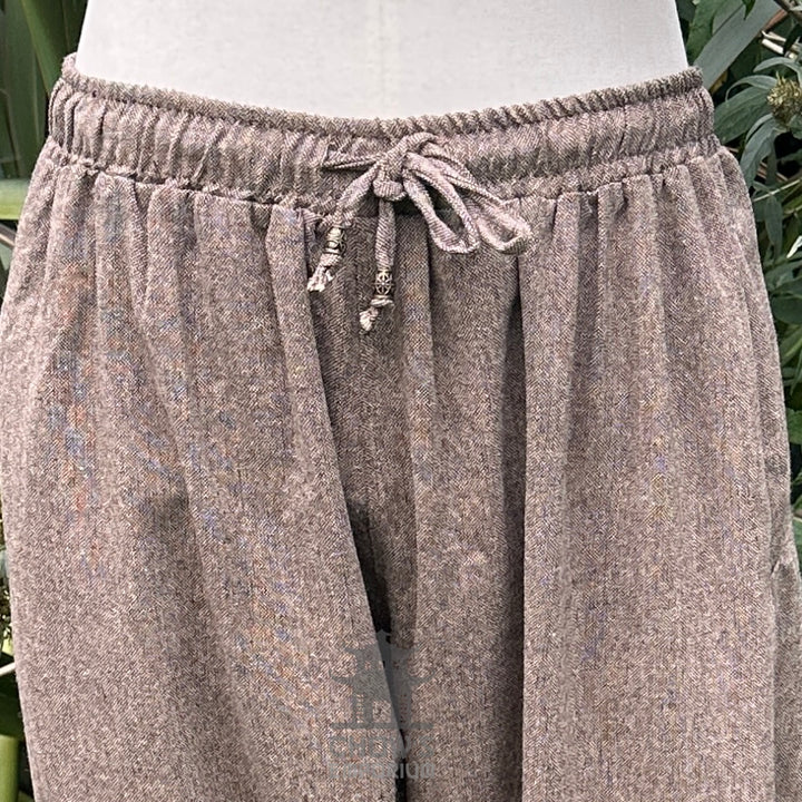 close up of drawstring detail on brown wool pants