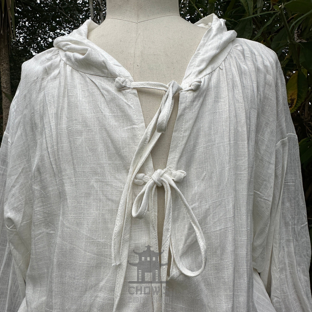 White hooded medieval LARP shirt with ties, front close-up on mannequin.