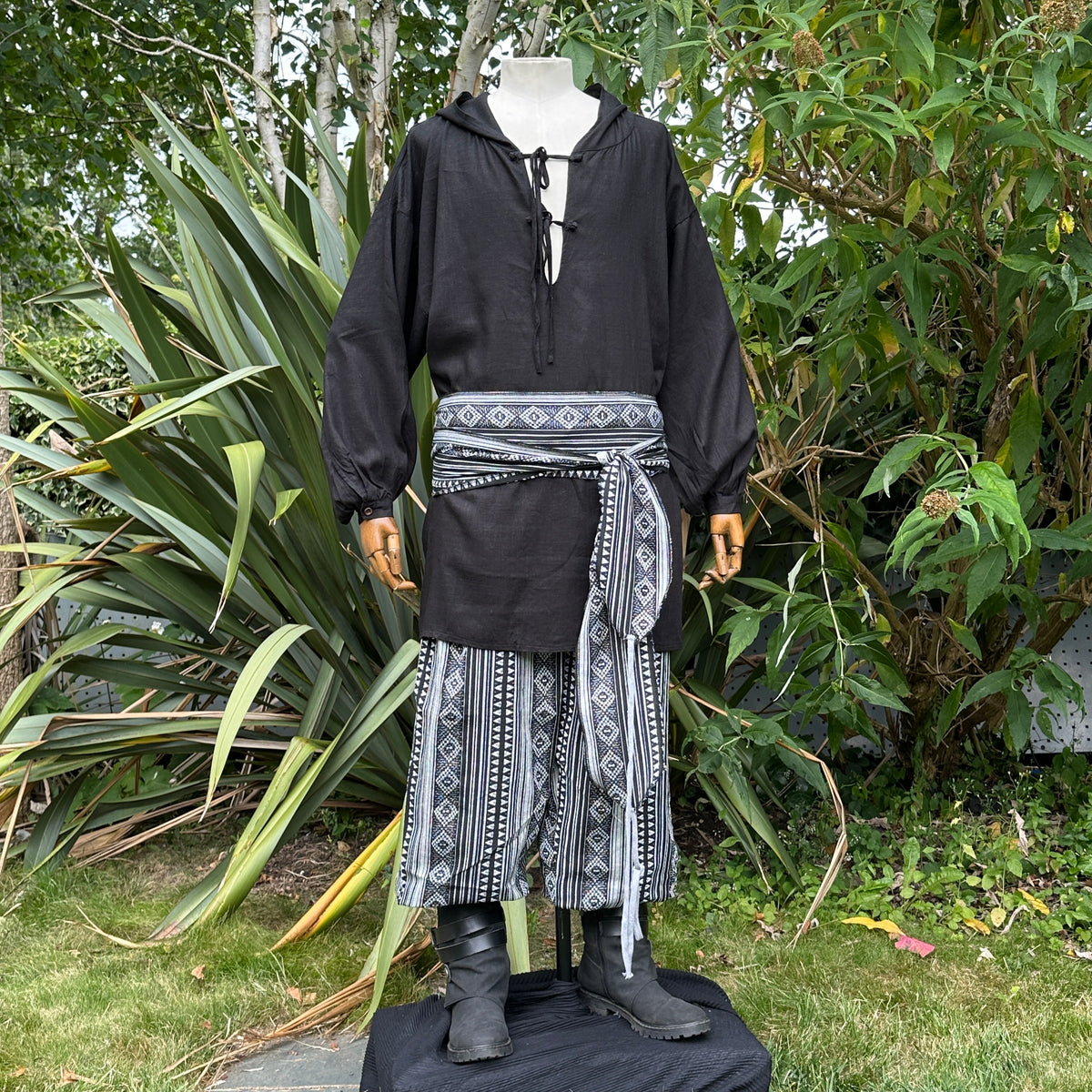Black hooded shirt, patterned pants, and sash, medieval LARP style outfit.
