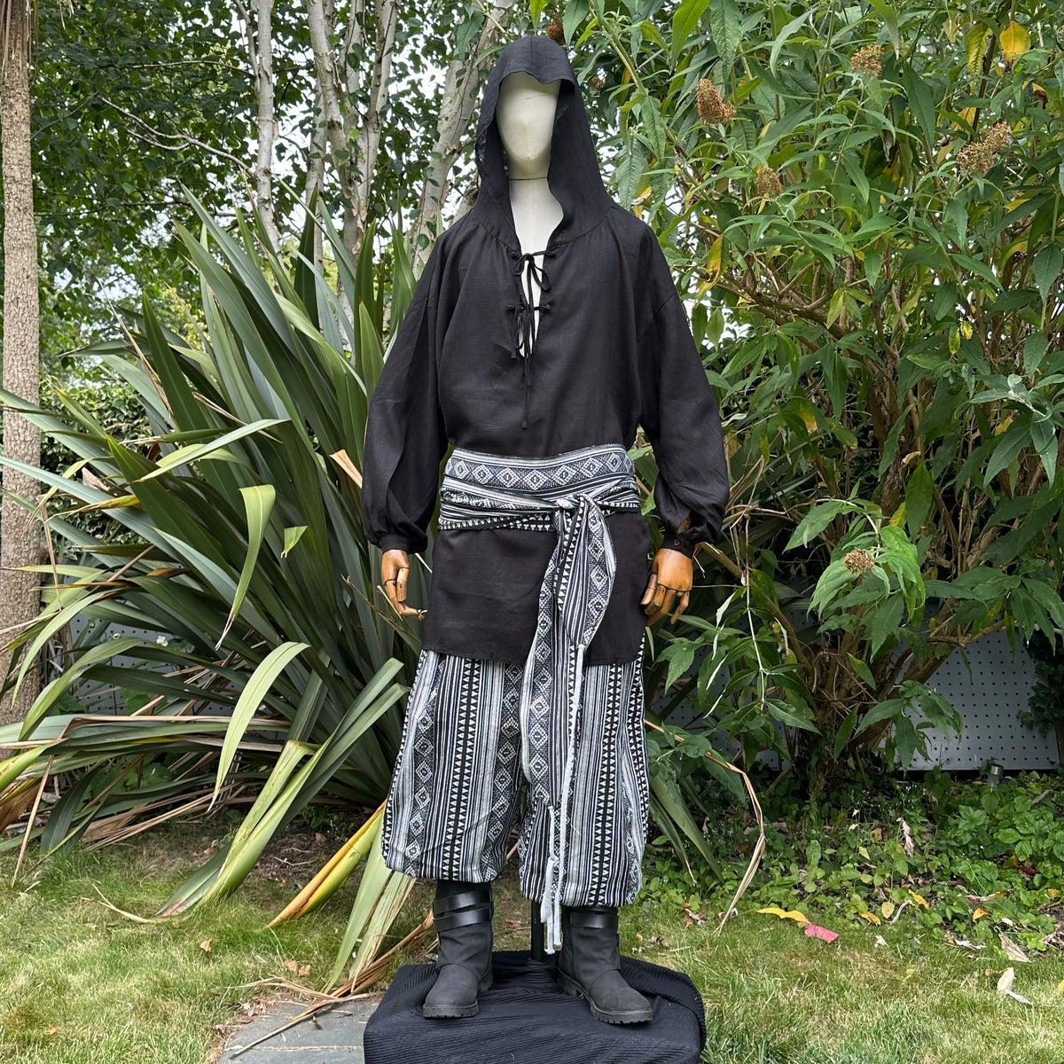 Medieval LARP outfit front view, featuring a black hooded shirt, black and white trousers and.