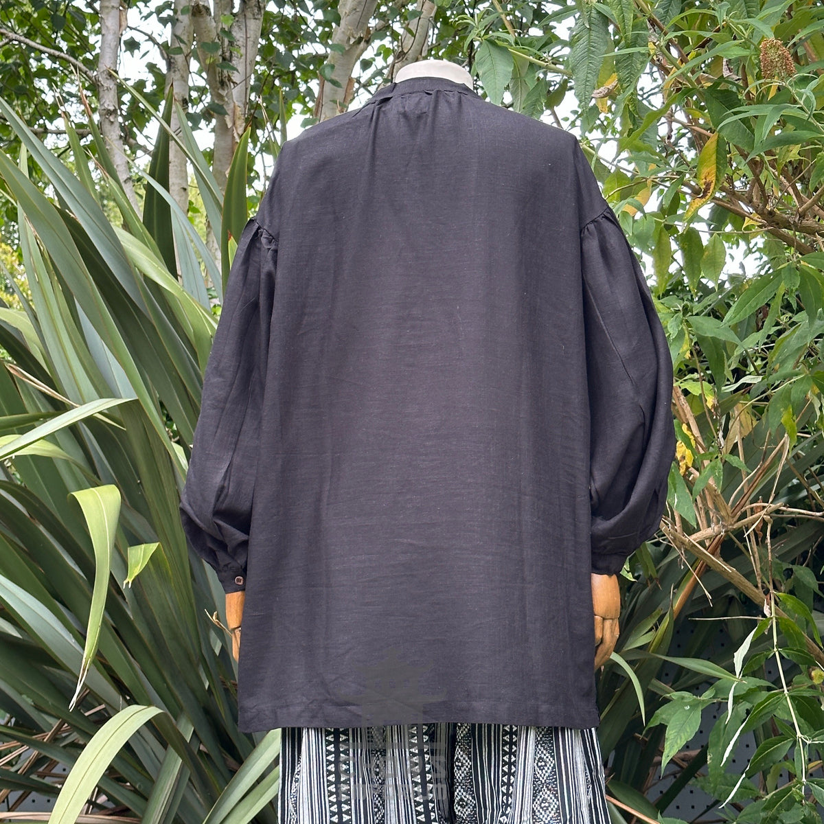 Back view of a black, cotton and linen medieval shirt for LARP.