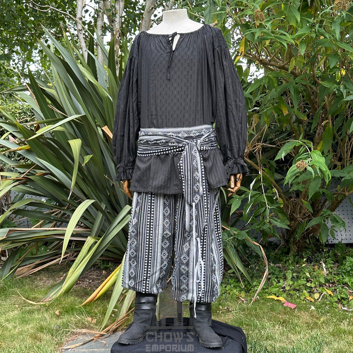 Medieval LARP outfit front view, featuring a black shirt, patterned trousers and sash.