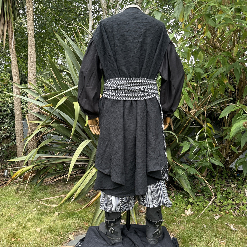 Medieval LARP costume back view, includes black and white waistcoat with asymmetrical front panel and matching sash, shirt, and trousers for Ren Faire and roleplay events.