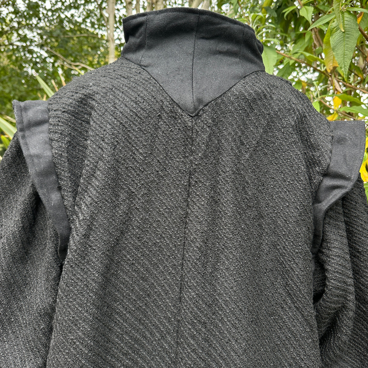 Close-up of wool fabric texture and contrasting panel detail on black medieval LARP robe.