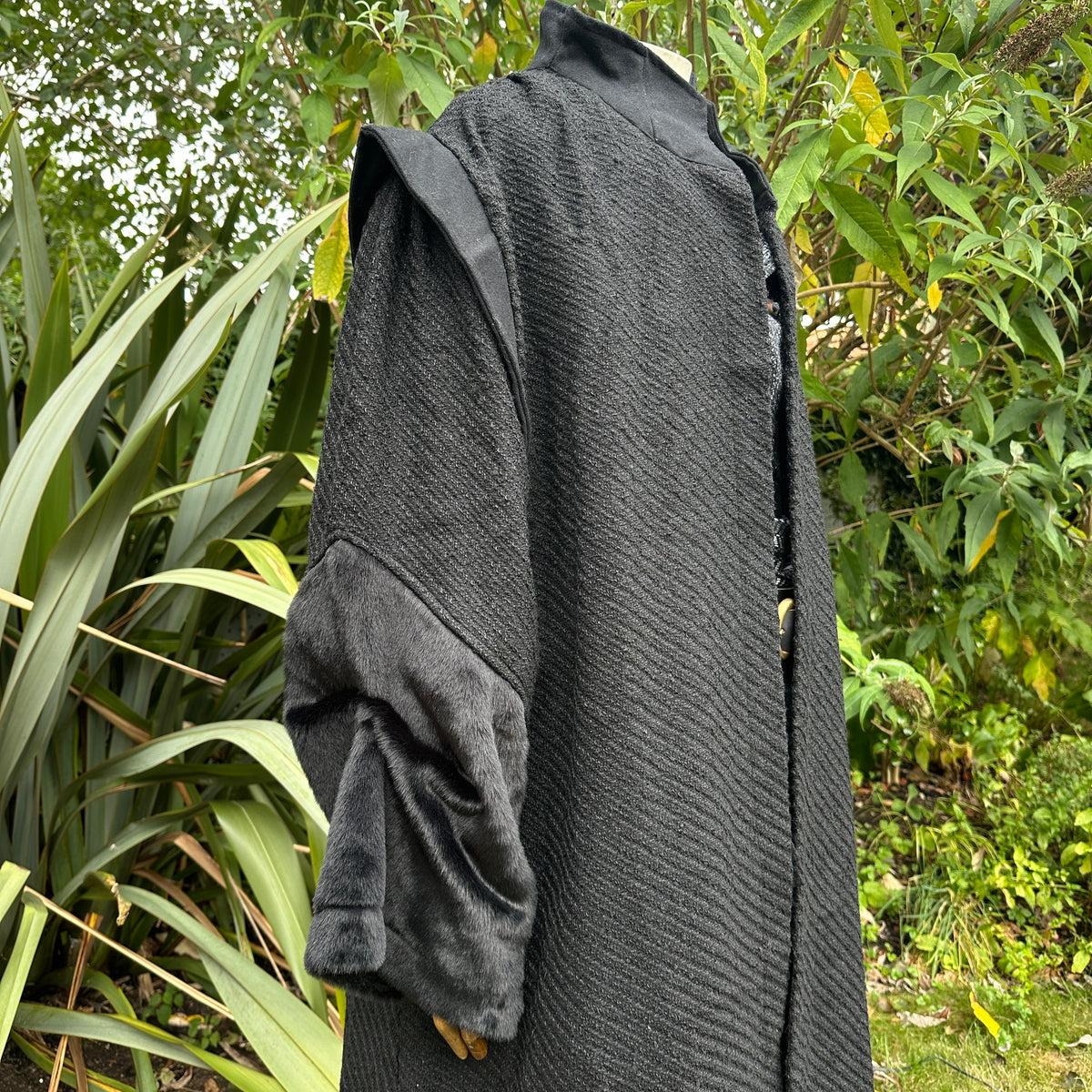 Close-up of contrasting sleeve design on black medieval LARP robe, fantasy cosplay costume for.