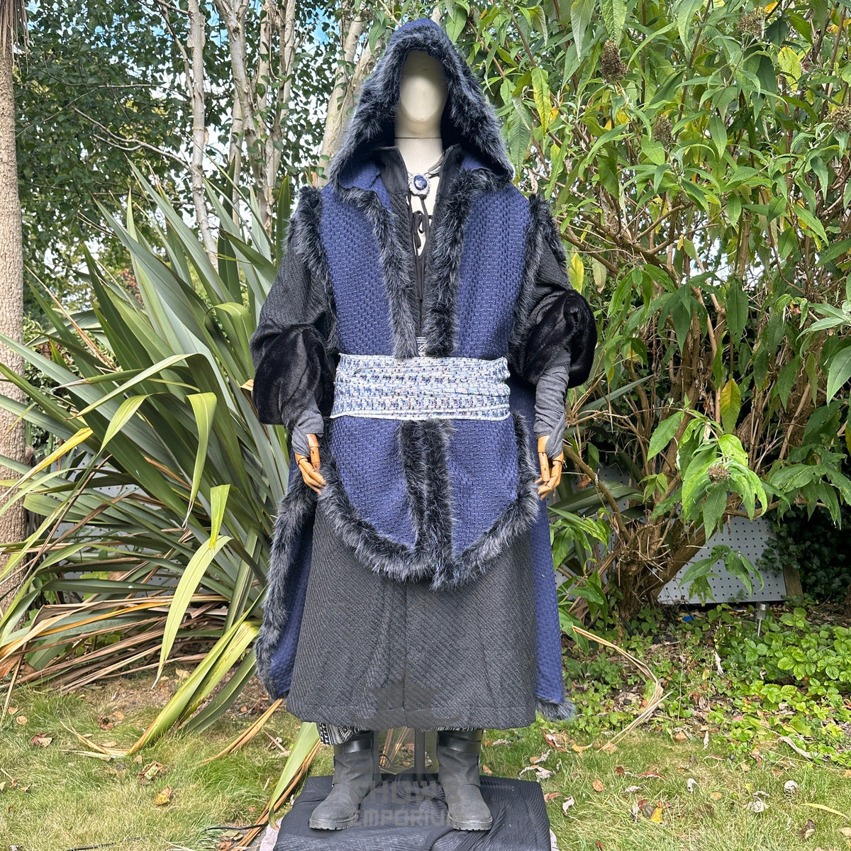 Medieval LARP outfit with fur-lined blue cape, black robe, and ornate belt.