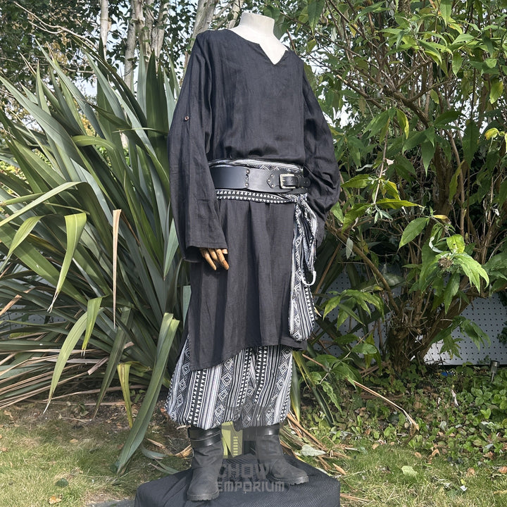 Medieval LARP outfit side view, featuring a black tunic, patterned trousers and sash. For Renaissance Faire and historical roleplay events.