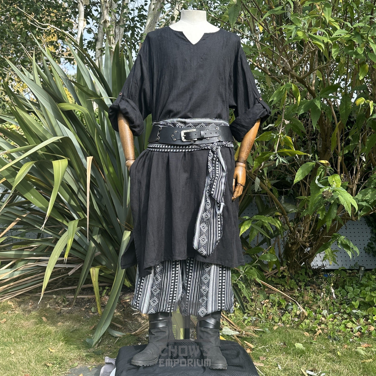 Medieval LARP outfit front view, featuring a black tunic, patterned trousers and sash.