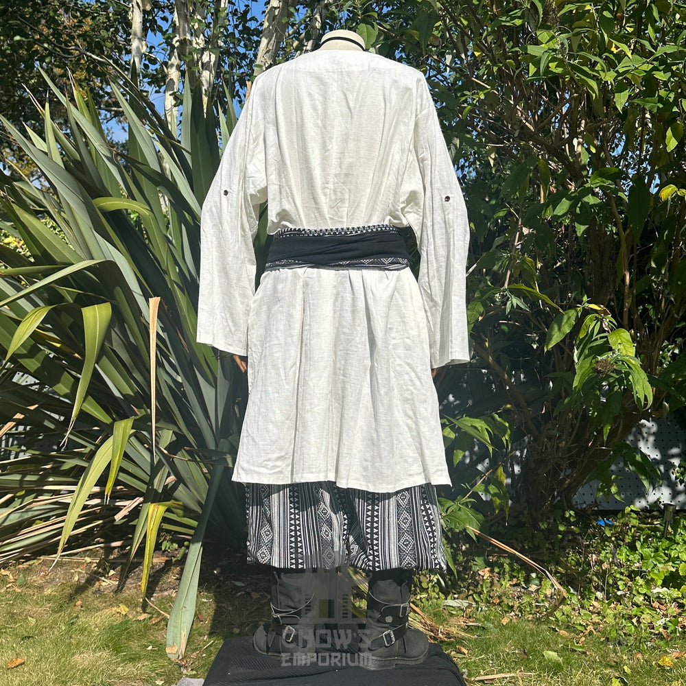 Medieval LARP outfit back view, featuring a white tunic, black & white trousers and matching sash. For Renaissance Faire and historical roleplay events.