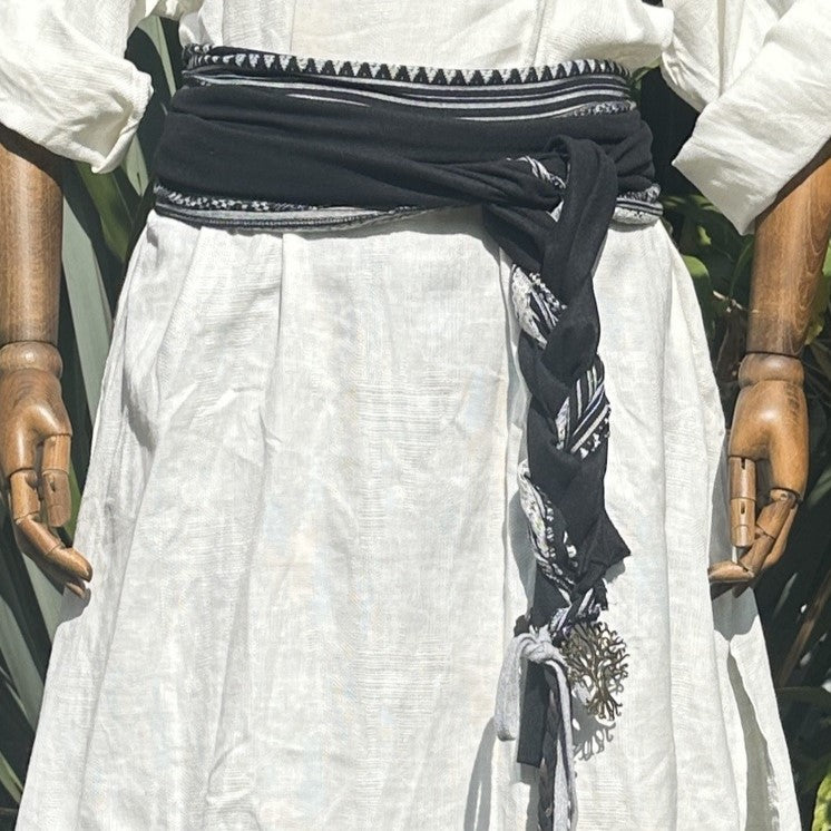 White tunic and black belt with sashes, front view.