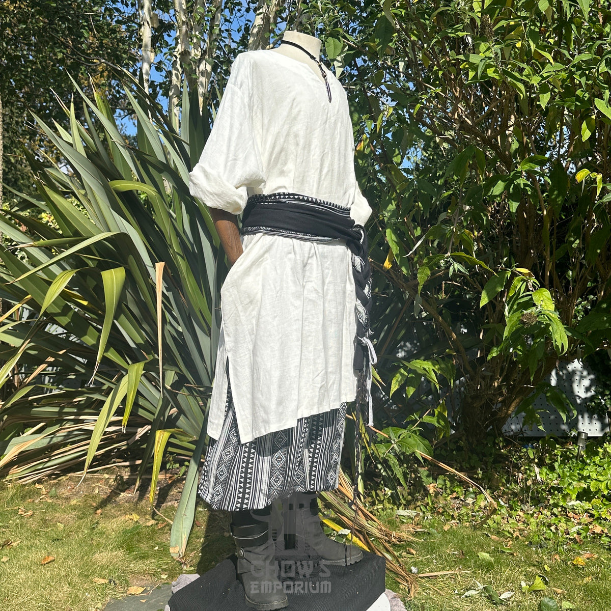White tunic with black sash and patterned trousers, side view, LARP outfit.