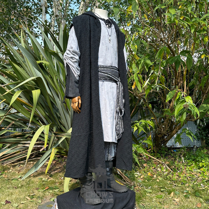 Medieval LARP outfit side view, featuring a black hooded robe, grey tunic, and sash. For Renaissance Faire and historical roleplay events.
