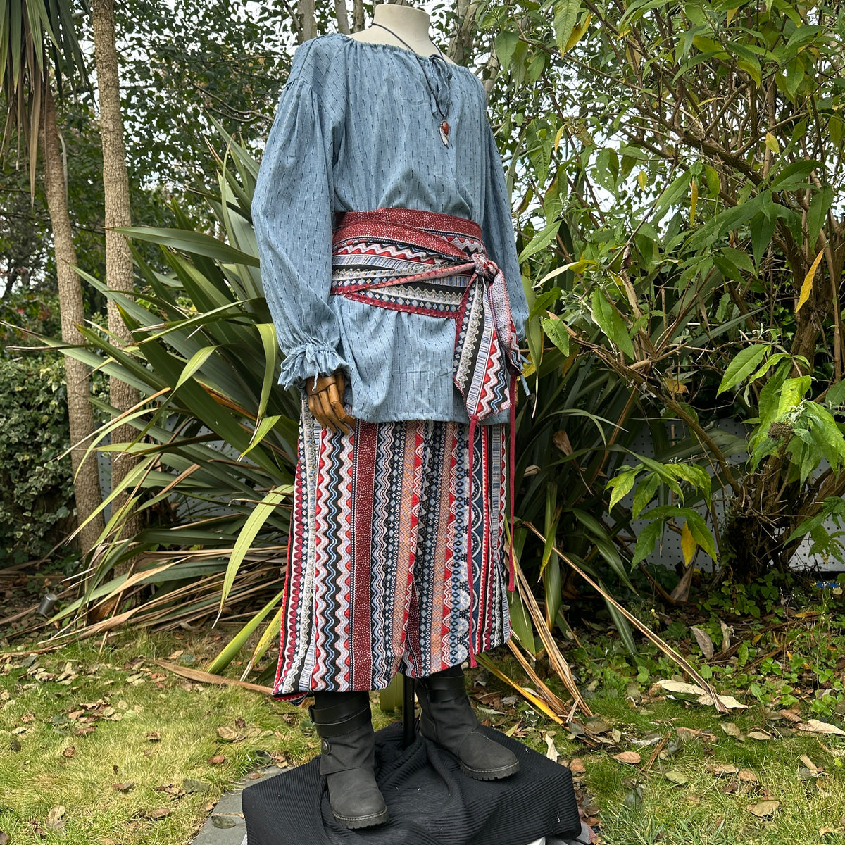 Medieval LARP outfit side view, featuring a blue shirt, trousers, and sash.