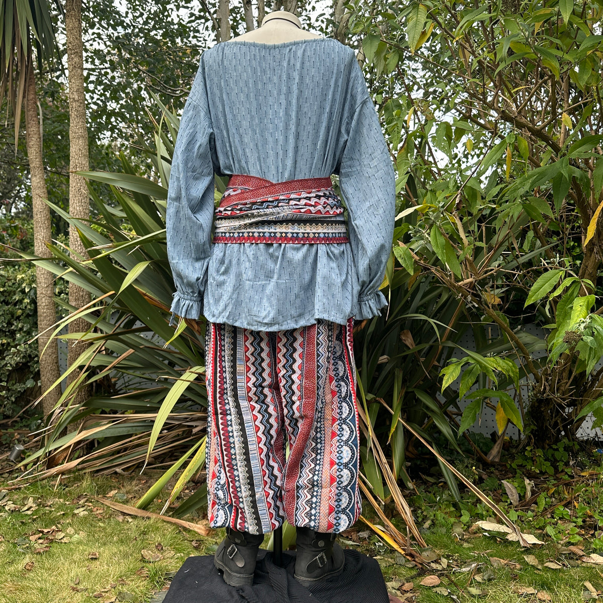 Medieval LARP outfit back view, featuring a blue shirt, trousers, and sash.