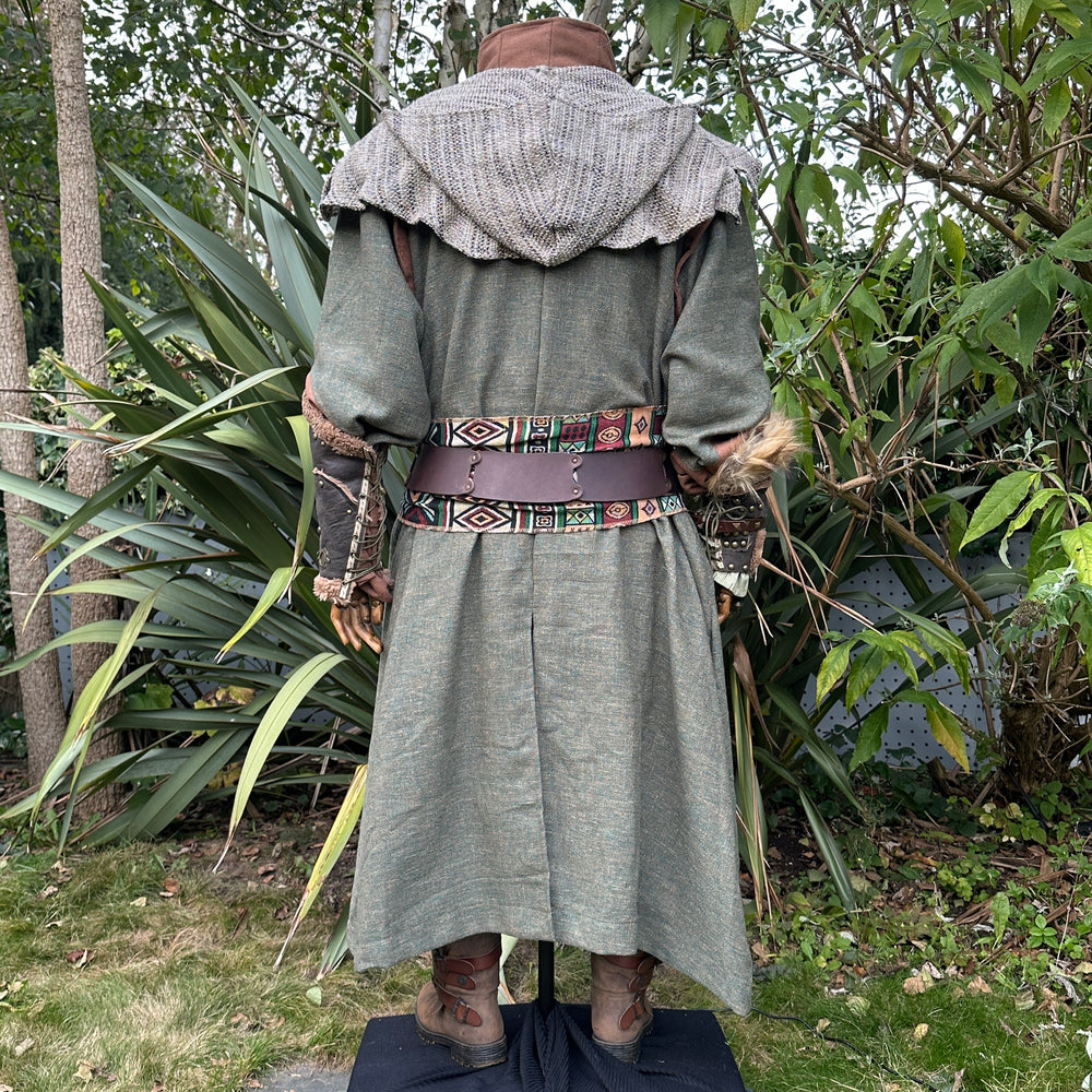 Medieval LARP costume back view featuring green robe, wool hood, vambraces, belt, sash and necklace. For Renaissance Faire and historical roleplay events.