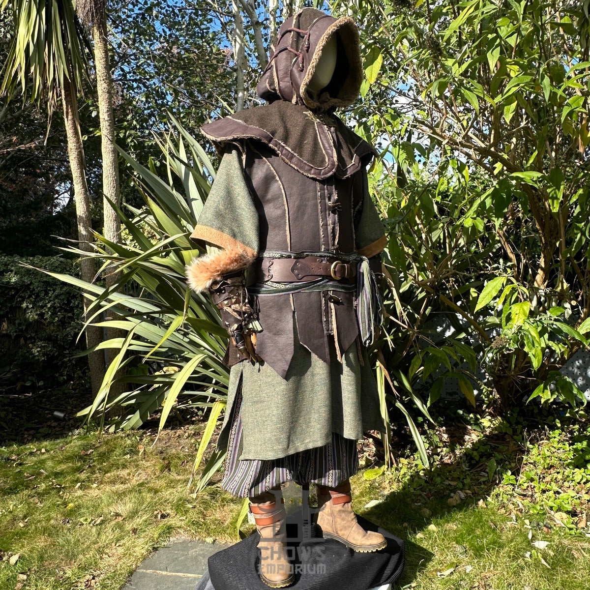 Medieval LARP costume side view, featuring brown leather waistcoat, hood and vambraces, a tunic.