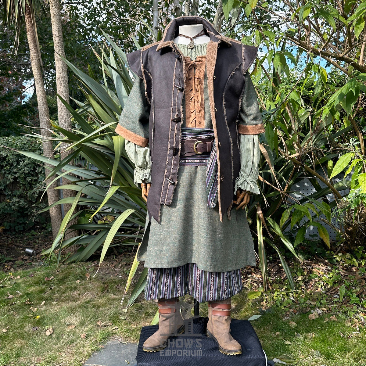 Green tunic under brown waistcoat, striped sash; medieval LARP attire.
